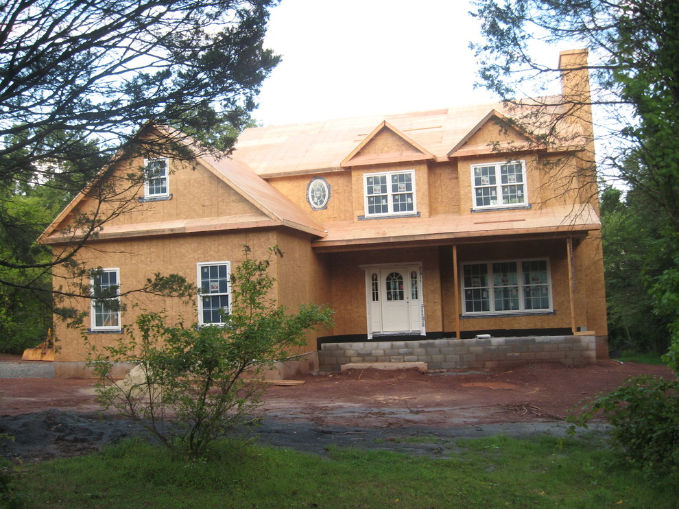This is an example of a large traditional two-storey beige house exterior in New York with mixed siding and a shingle roof.