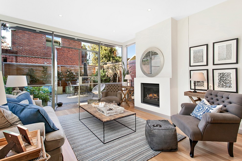 Transitional formal living room in Melbourne with beige walls, light hardwood floors, a standard fireplace and no tv.