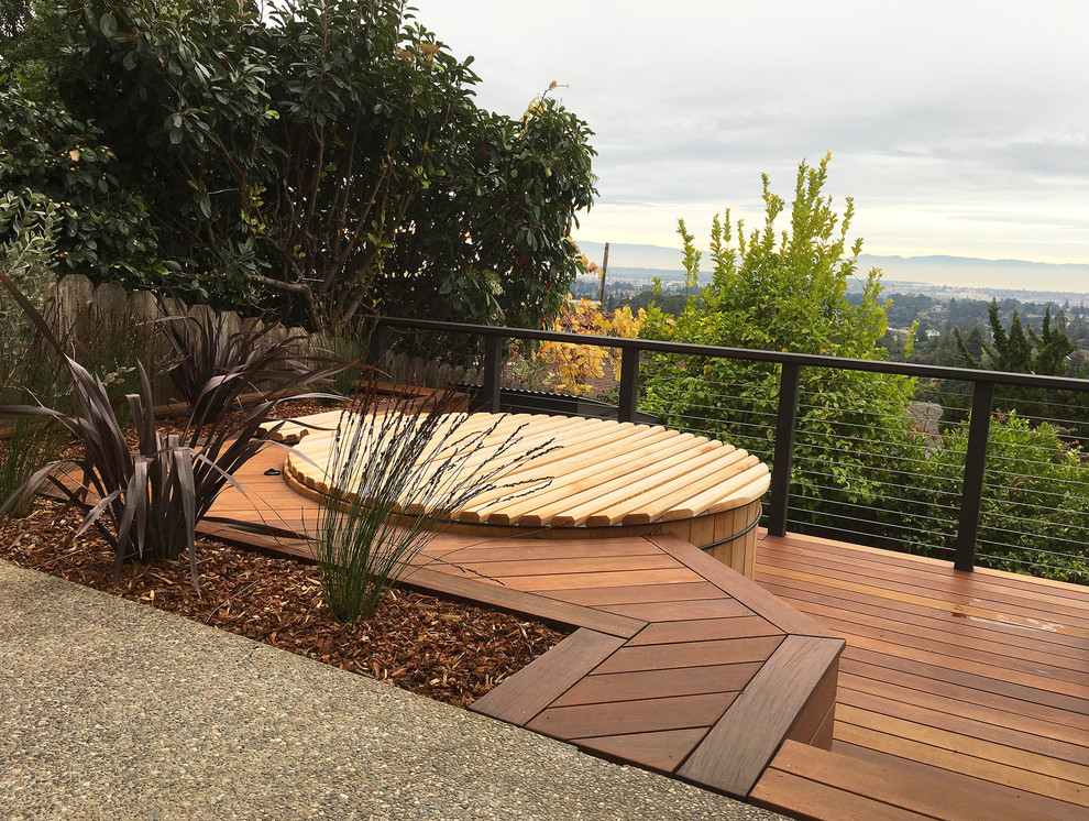 This is an example of a small contemporary backyard round aboveground pool in San Francisco with a hot tub and decking.