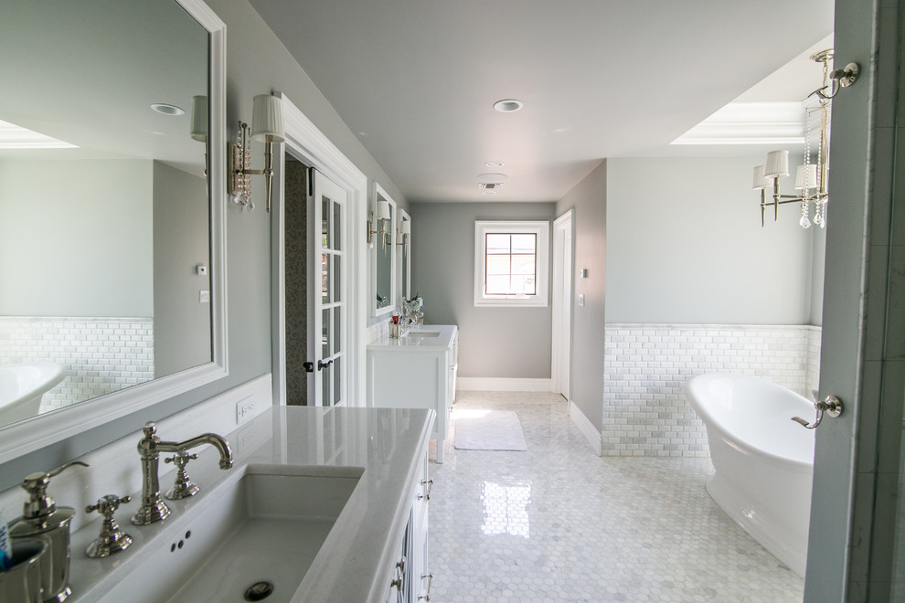 Photo of an expansive transitional master bathroom in Miami with glass-front cabinets, white cabinets, a freestanding tub, a double shower, a one-piece toilet, grey walls, marble floors, an undermount sink and quartzite benchtops.