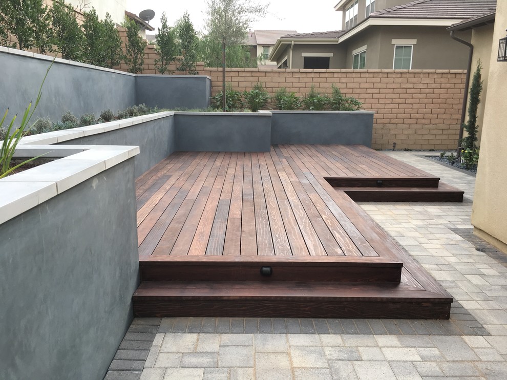 Photo of a modern backyard partial sun xeriscape in Los Angeles with a retaining wall and decking.