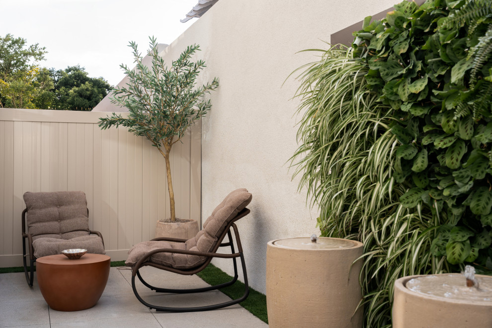 Example of a tuscan courtyard concrete paver patio vertical garden design in Los Angeles with no cover