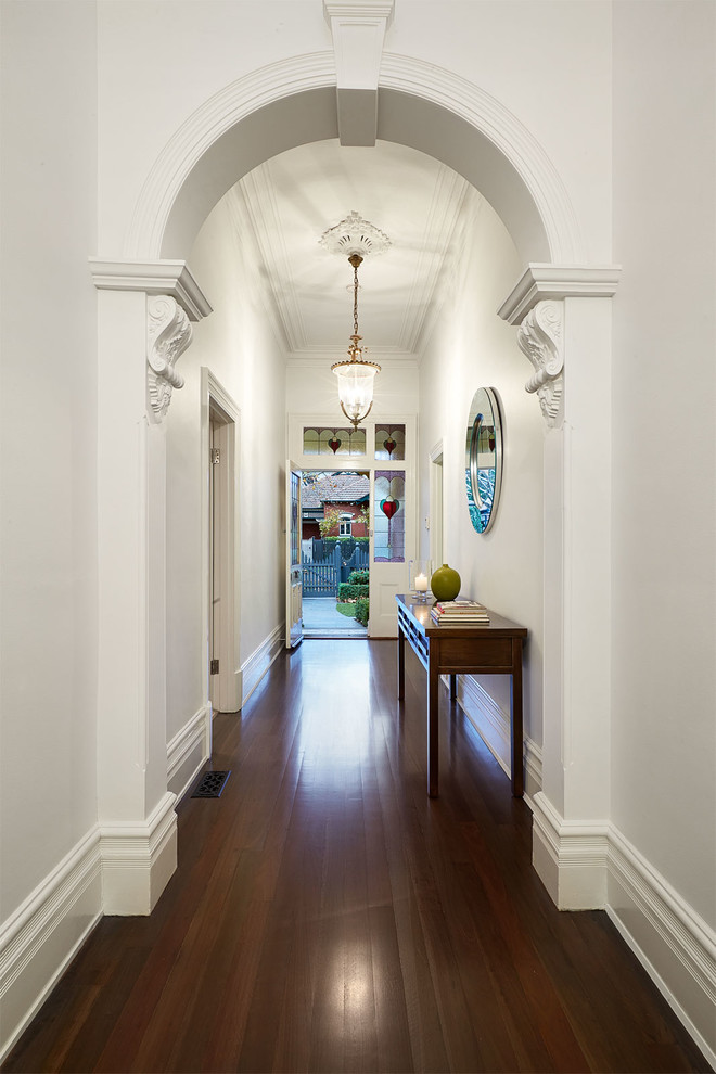 Photo of a mid-sized traditional foyer in Melbourne with white walls, dark hardwood floors, a single front door and a white front door.