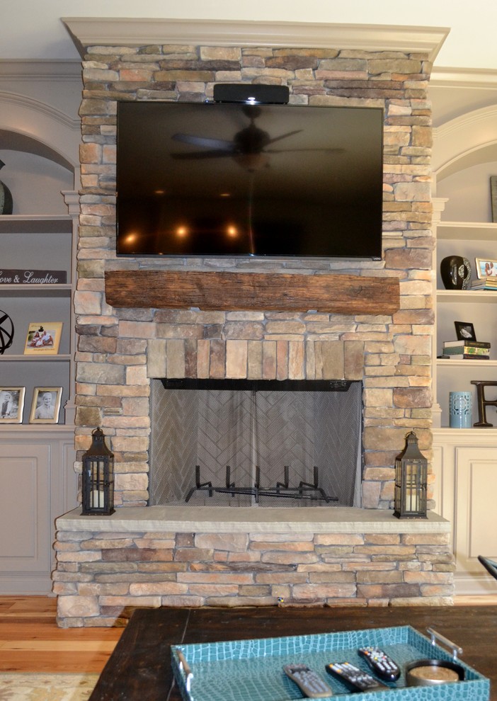 Mid-sized traditional open concept living room in Nashville with beige walls, medium hardwood floors, a standard fireplace, a stone fireplace surround and a wall-mounted tv.