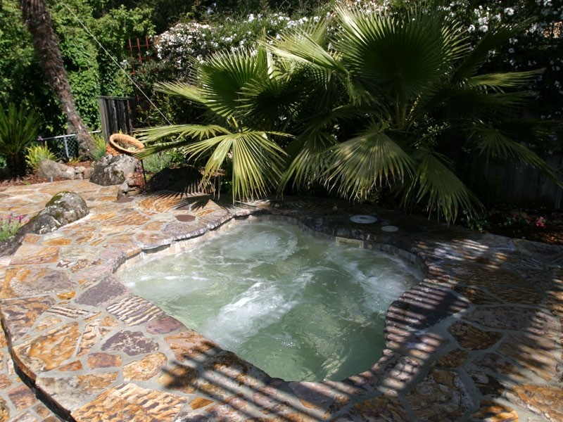 Backyard stone hot tub photo