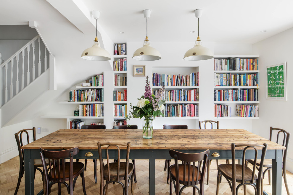 Klassische Wohnküche mit weißer Wandfarbe, hellem Holzboden und braunem Boden in London