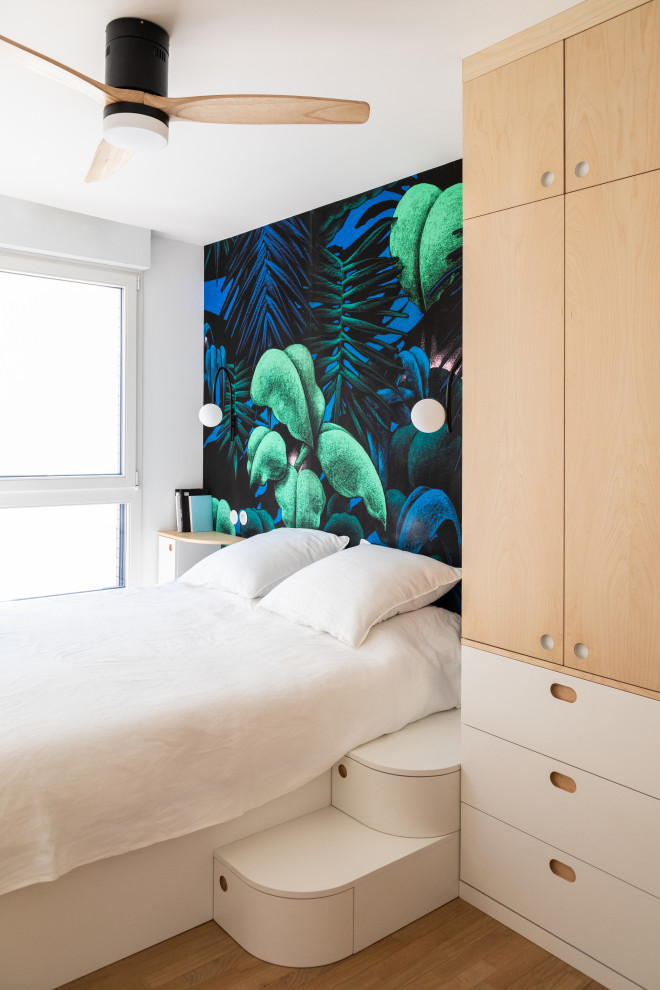 Imagen de dormitorio principal y blanco y madera minimalista pequeño con paredes multicolor, suelo de madera clara, suelo beige y papel pintado