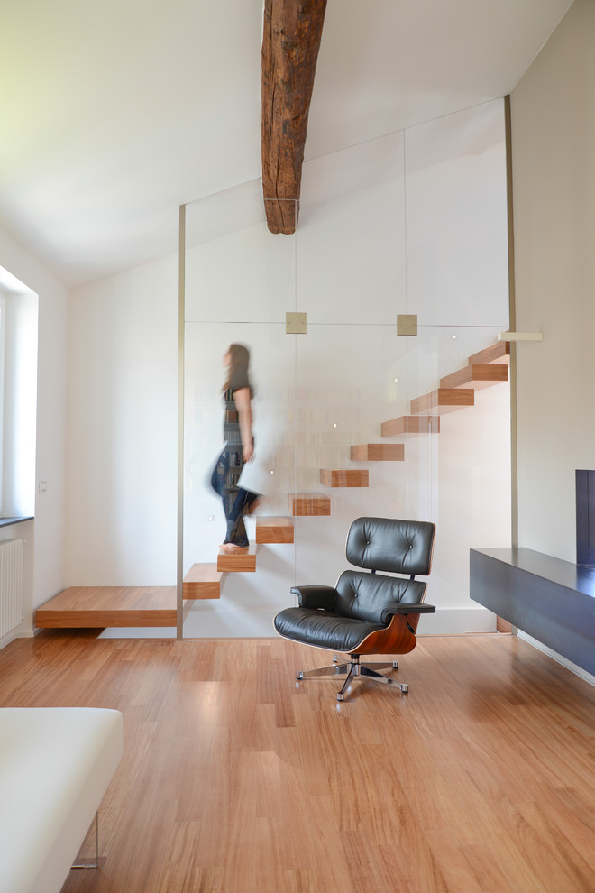 This is an example of a mid-sized modern wood straight staircase in Milan with open risers.