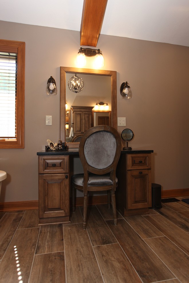 Large mountain style master slate tile brown floor freestanding bathtub photo in Indianapolis with brown cabinets, beige walls and an undermount sink