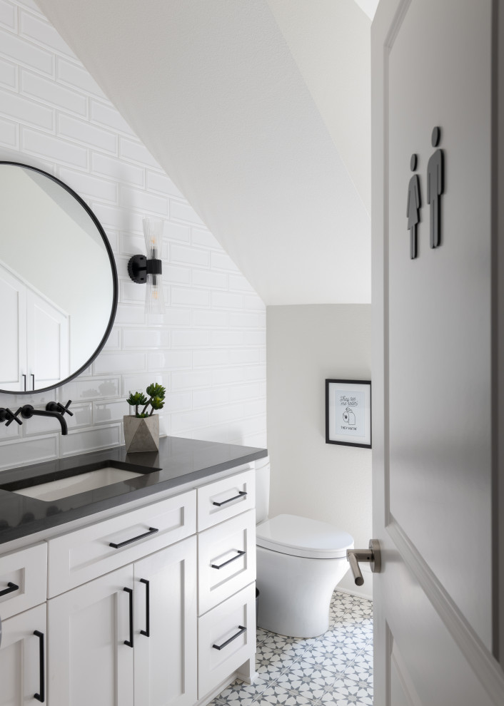 Mid-sized beach style kids bathroom in Dallas with shaker cabinets, white cabinets, a two-piece toilet, gray tile, subway tile, grey walls, ceramic floors, an undermount sink, engineered quartz benchtops, grey floor, black benchtops, a single vanity and a built-in vanity.