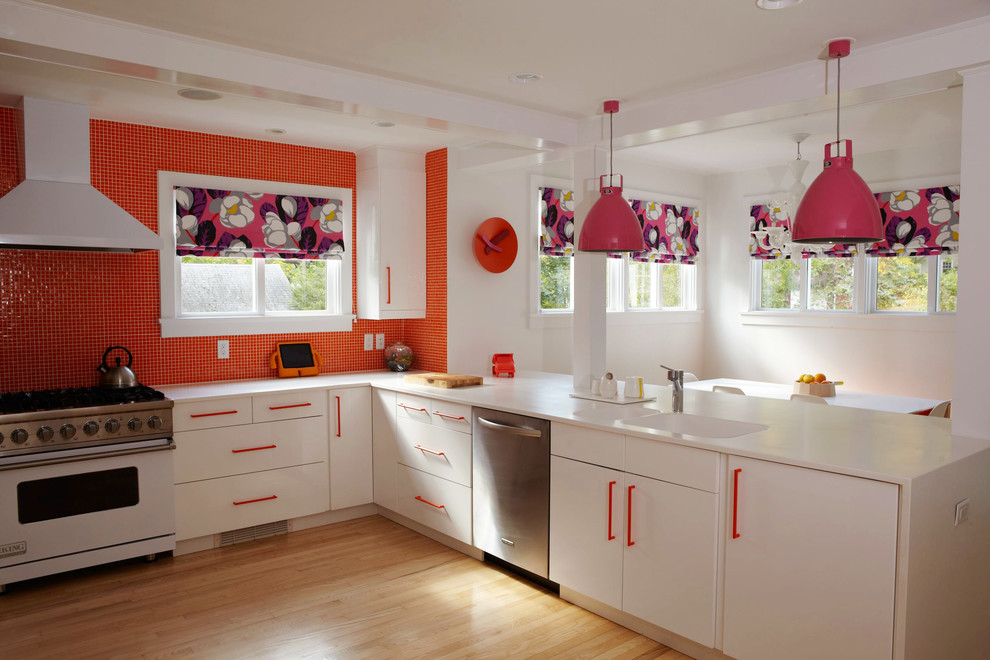 Design ideas for a large contemporary u-shaped eat-in kitchen in New York with an integrated sink, flat-panel cabinets, white cabinets, orange splashback, mosaic tile splashback, white appliances, solid surface benchtops, light hardwood floors and brown floor.