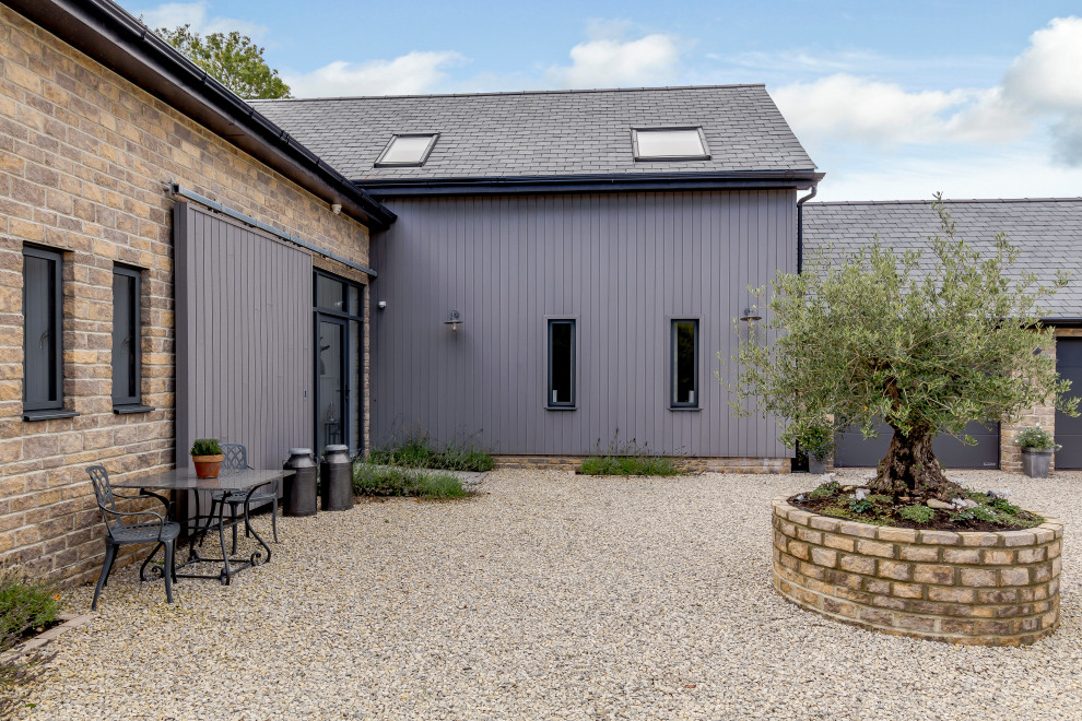 Mittelgroßes, Zweistöckiges Landhausstil Einfamilienhaus mit Mix-Fassade, beiger Fassadenfarbe, grauem Dach und Wandpaneelen in Devon