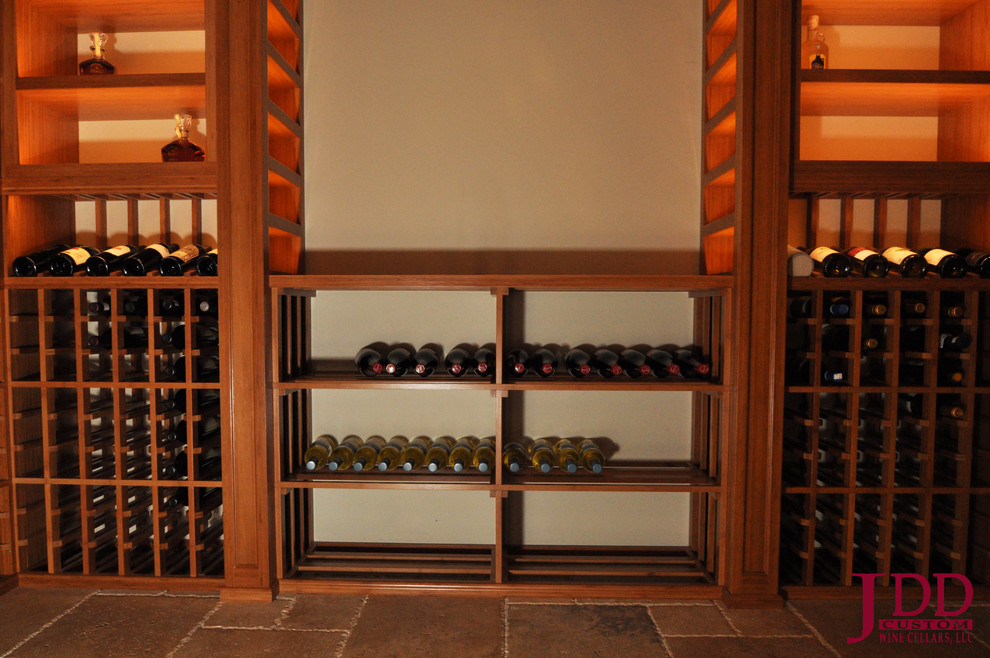 Photo of a large rustic wine cellar in San Diego with travertine flooring and storage racks.
