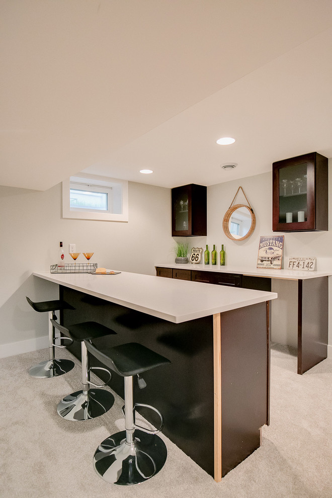 Design ideas for a mid-sized transitional galley seated home bar in Minneapolis with shaker cabinets, dark wood cabinets, quartz benchtops, carpet, brown floor and white benchtop.