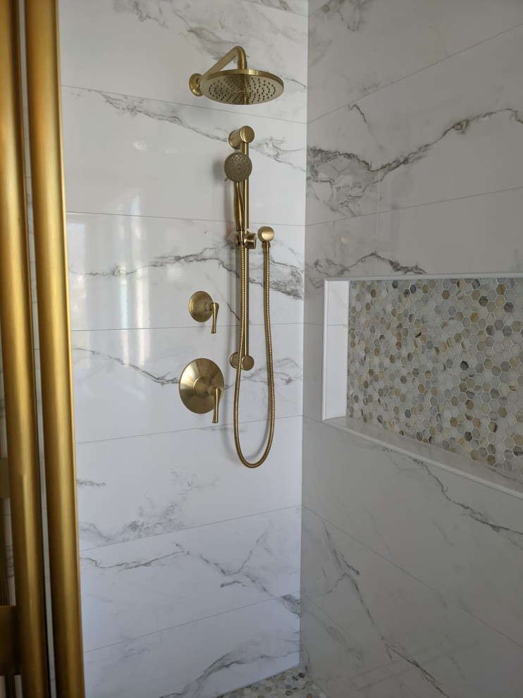 Inredning av ett flerfärgad flerfärgat badrum, med luckor med upphöjd panel, vita skåp, ett fristående badkar, en hörndusch, en vägghängd toalettstol, vit kakel, vita väggar, ett undermonterad handfat, marmorbänkskiva, grått golv och dusch med skjutdörr