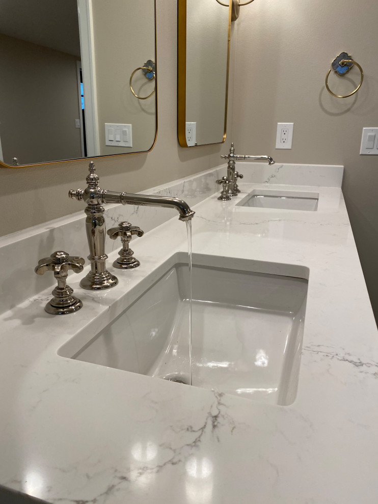 This is an example of a large arts and crafts master bathroom in Seattle with shaker cabinets, white cabinets, a freestanding tub, an open shower, a two-piece toilet, white tile, marble, beige walls, vinyl floors, an undermount sink, engineered quartz benchtops, brown floor, a hinged shower door, pink benchtops, a double vanity and a built-in vanity.