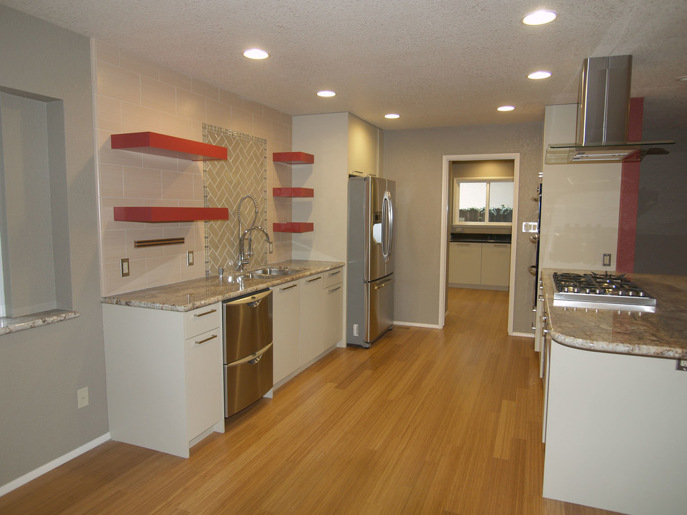 Design ideas for a small modern galley eat-in kitchen in Sacramento with an undermount sink, flat-panel cabinets, beige cabinets, granite benchtops, beige splashback, glass tile splashback, stainless steel appliances, bamboo floors and a peninsula.