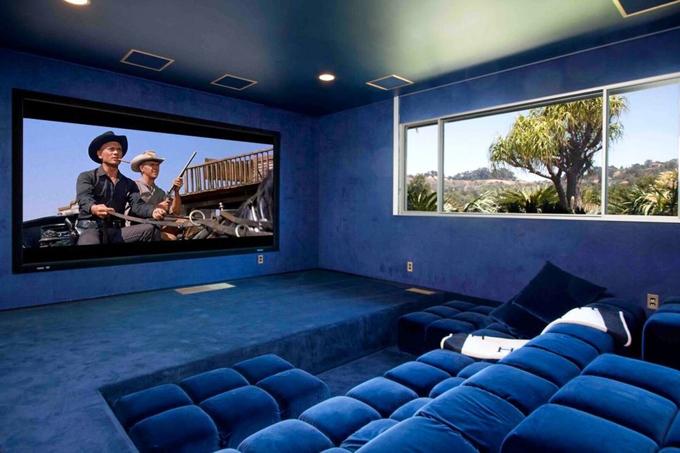 This is an example of a midcentury home theatre in Los Angeles with blue walls, carpet, a projector screen and blue floor.