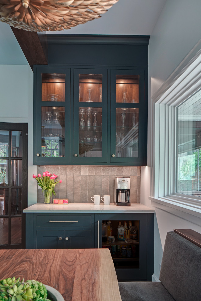 This is an example of a small transitional single-wall home bar in Chicago with no sink, glass-front cabinets, blue cabinets, quartz benchtops, grey splashback, ceramic splashback, porcelain floors, grey floor and white benchtop.