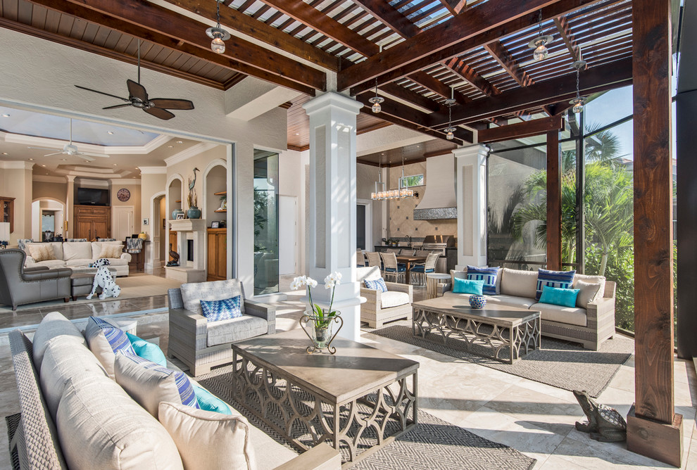 This is an example of a mid-sized transitional backyard patio in Miami with natural stone pavers and a pergola.
