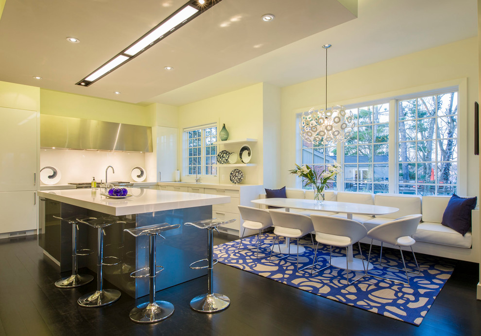 Photo of a large modern u-shaped eat-in kitchen in DC Metro with a double-bowl sink, flat-panel cabinets, white cabinets, quartz benchtops, white splashback, glass sheet splashback, stainless steel appliances, dark hardwood floors and with island.