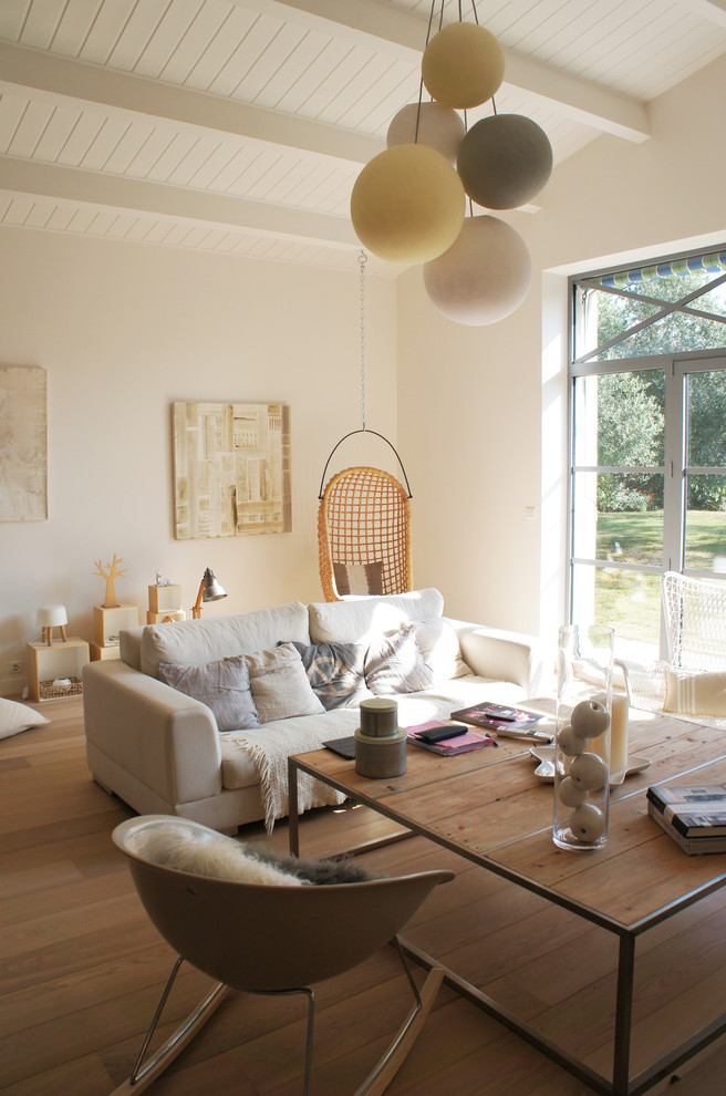 Photo of a mid-sized contemporary open concept living room in Nantes with white walls, no fireplace, no tv and light hardwood floors.