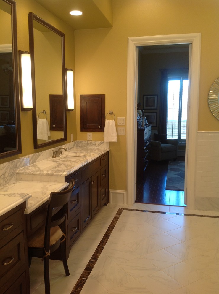 Design ideas for a traditional bathroom in Dallas with an undermount sink, shaker cabinets, brown cabinets, marble benchtops, a freestanding tub, a corner shower, white tile and stone tile.