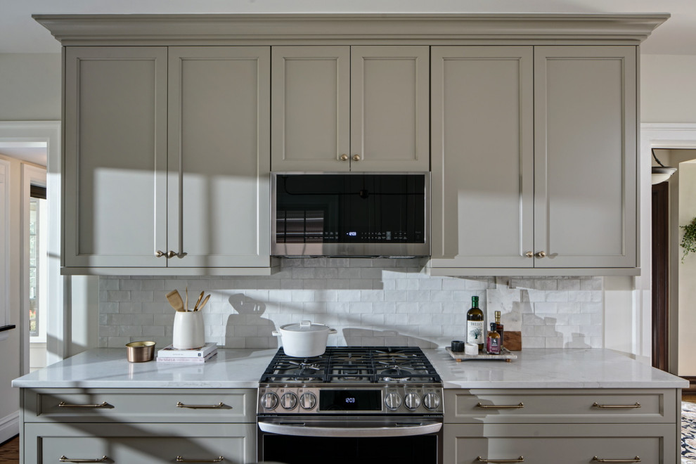 Example of a mid-sized transitional eat-in kitchen design in Chicago with recessed-panel cabinets, gray cabinets, quartz countertops, white backsplash, subway tile backsplash, an island and white countertops