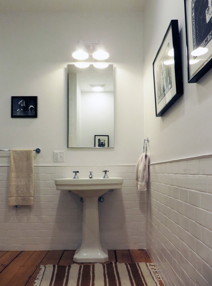 Mid-sized traditional 3/4 bathroom in Burlington with a pedestal sink, an alcove shower, a two-piece toilet, white tile, subway tile, white walls and medium hardwood floors.
