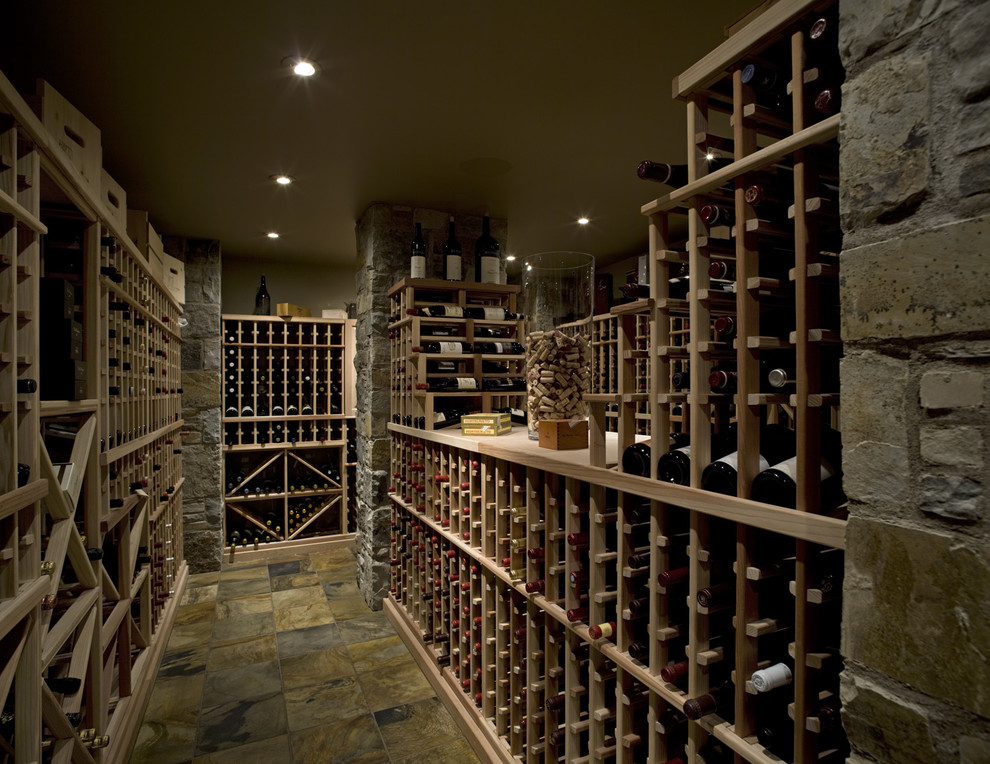 Inspiration for a mid-sized arts and crafts wine cellar in Calgary with storage racks and green floor.