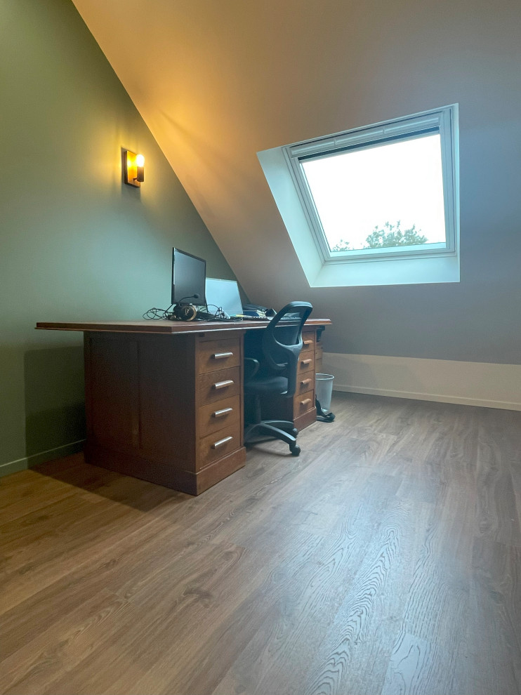 Imagen de despacho contemporáneo pequeño con paredes verdes, suelo laminado y escritorio independiente