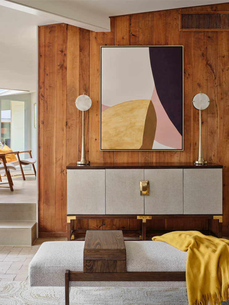 На фото: большая открытая гостиная комната в стиле ретро с коричневыми стенами, кирпичным полом, стандартным камином, фасадом камина из штукатурки, телевизором на стене, коричневым полом, балками на потолке и деревянными стенами с