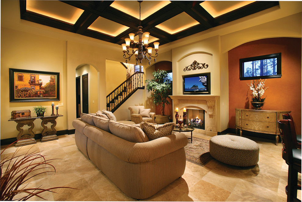 Inspiration for a large mediterranean open concept family room in Miami with multi-coloured walls, travertine floors, a standard fireplace, a stone fireplace surround and a built-in media wall.