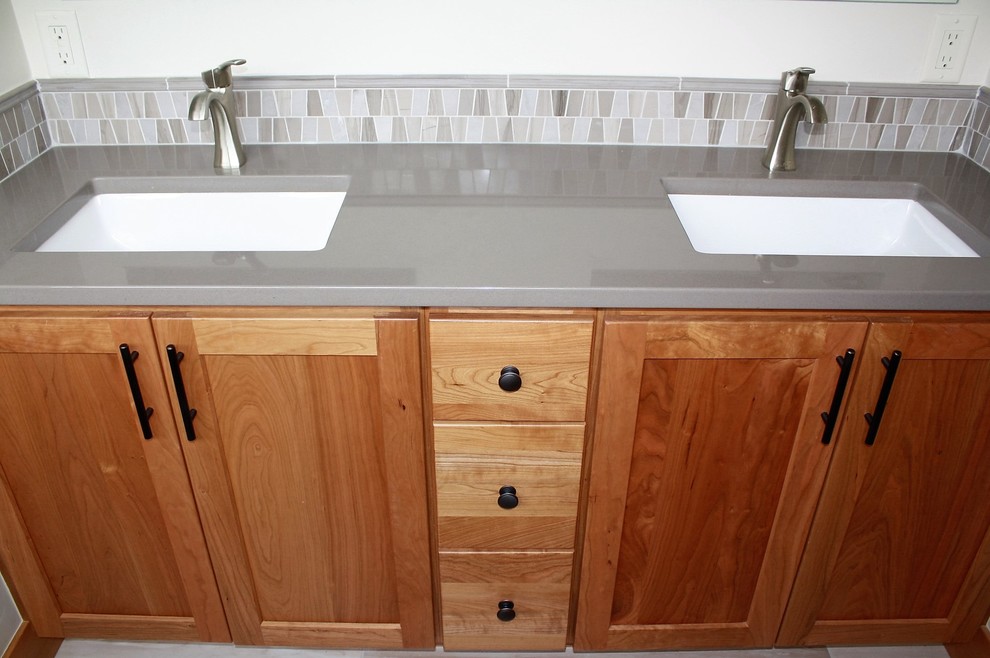 Gray tile and porcelain tile porcelain tile corner shower photo with an undermount sink and quartz countertops