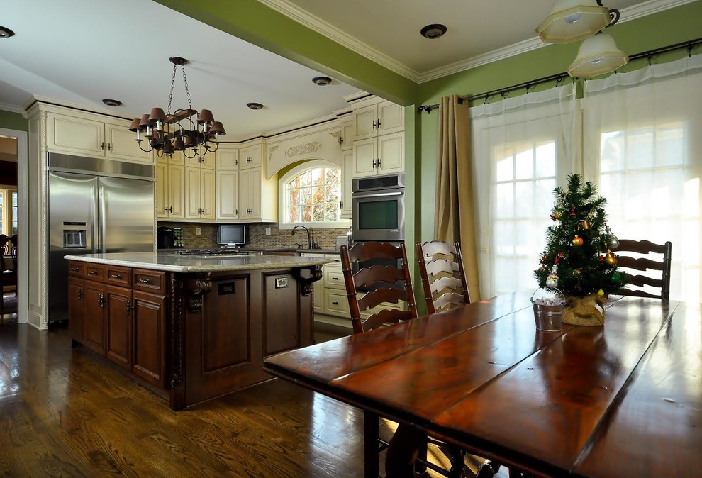 Inspiration for a mid-sized transitional l-shaped dark wood floor eat-in kitchen remodel with raised-panel cabinets, white cabinets, multicolored backsplash, mosaic tile backsplash, stainless steel appliances, an island, a farmhouse sink and granite countertops