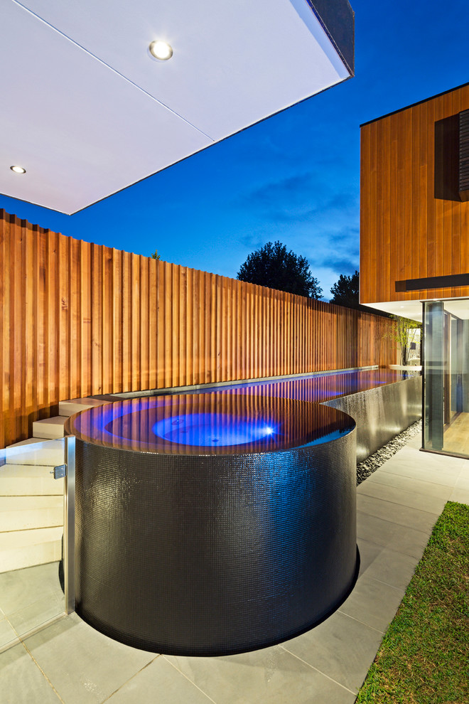 Contemporary rectangular aboveground pool in Melbourne with a hot tub.