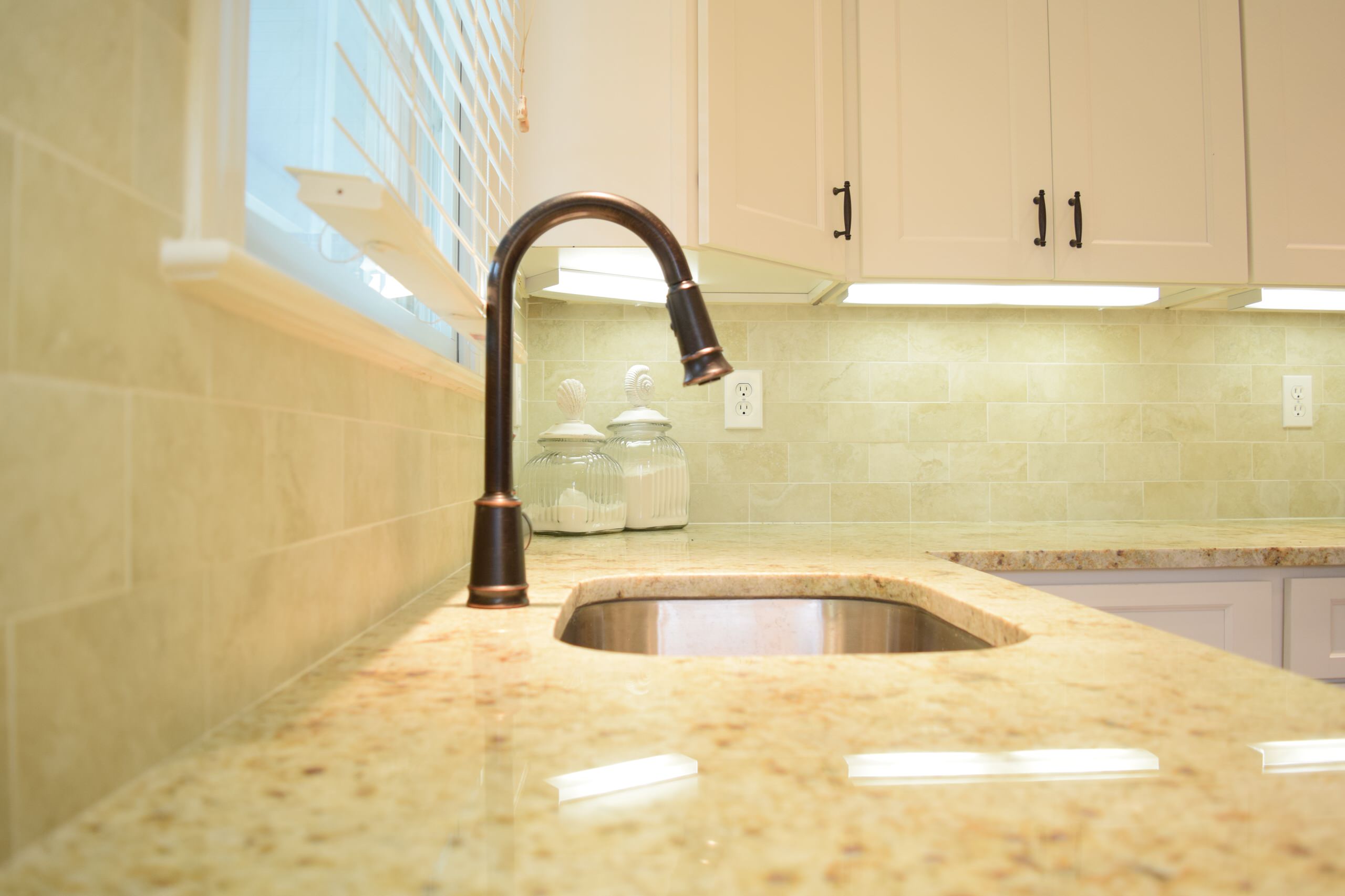 Colonial cream granite countertops with oil rubbed bronze goose neck faucet