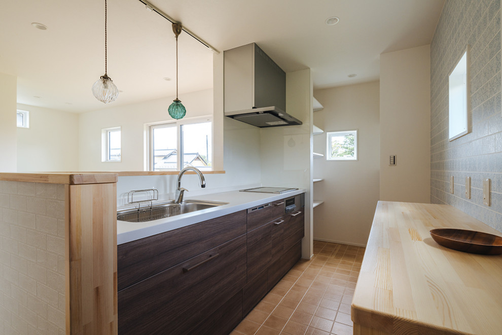 Einzeilige, Mittelgroße Küche mit Küchenrückwand in Braun, Sperrholzboden, orangem Boden, beiger Arbeitsplatte und Tapetendecke in Sonstige