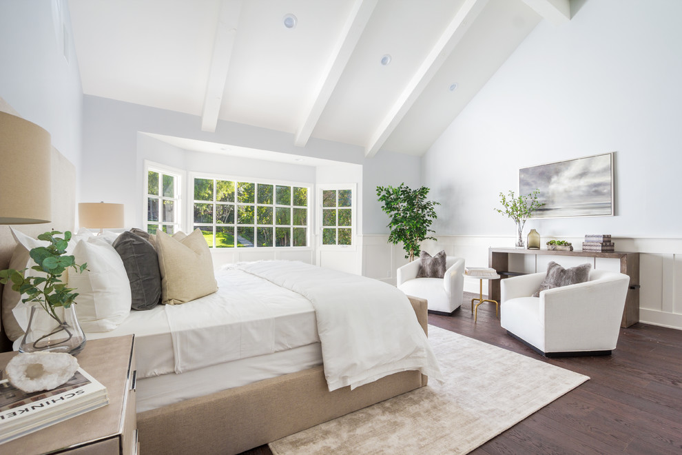 This is an example of a transitional master bedroom in Los Angeles with dark hardwood floors and grey walls.