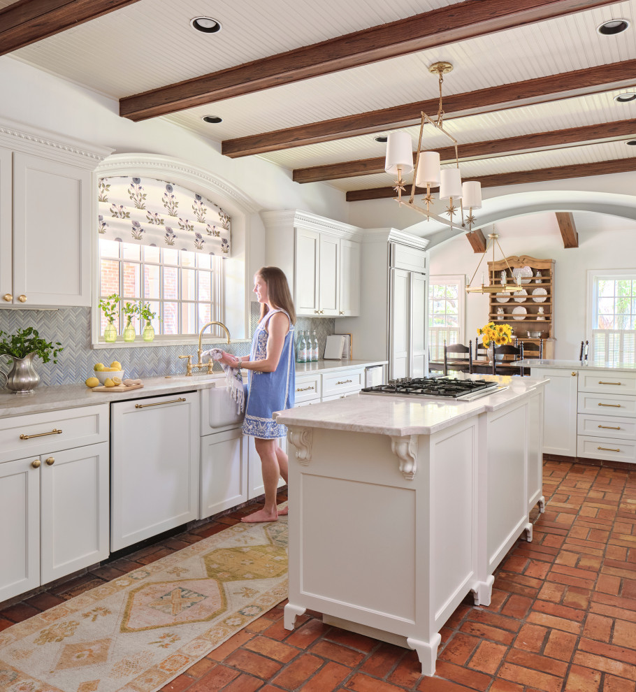 Inspiration for a timeless l-shaped terra-cotta tile and exposed beam eat-in kitchen remodel in Austin with recessed-panel cabinets, white cabinets, marble countertops, blue backsplash, an island, white countertops, glass tile backsplash, a farmhouse sink and paneled appliances
