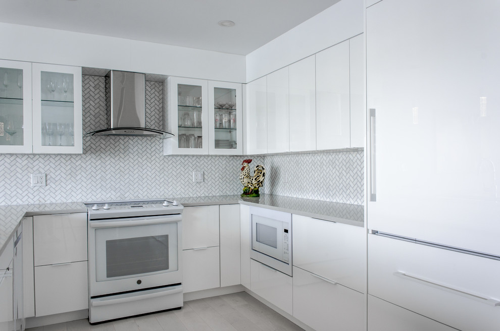 This is an example of a mid-sized modern u-shaped eat-in kitchen in Providence with an undermount sink, flat-panel cabinets, white cabinets, quartz benchtops, grey splashback, white appliances, painted wood floors, grey floor and grey benchtop.