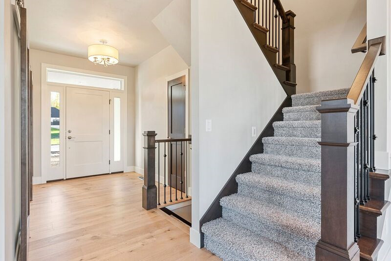 Example of a transitional light wood floor foyer design with gray walls and a white front door