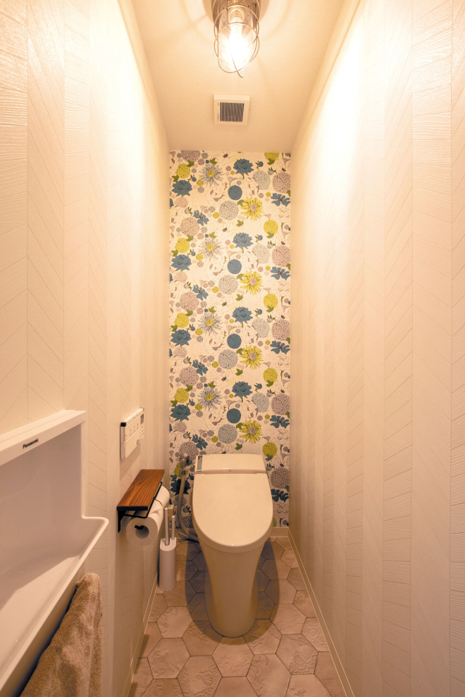 Small scandinavian powder room in Other with beaded inset cabinets, white cabinets, multi-coloured walls, vinyl floors, a wall-mount sink, beige floor, a two-piece toilet, wallpaper and wallpaper.