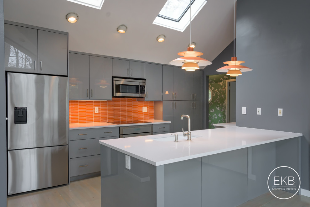 Design ideas for a mid-sized modern single-wall eat-in kitchen in New York with an undermount sink, flat-panel cabinets, grey cabinets, quartz benchtops, orange splashback, glass tile splashback, stainless steel appliances, light hardwood floors, a peninsula, multi-coloured floor and white benchtop.