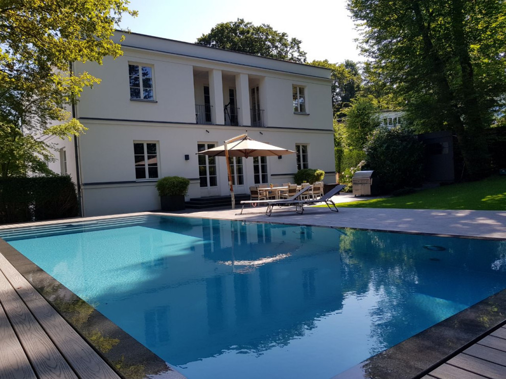 This is an example of a large contemporary side yard rectangular pool in Frankfurt with decking.