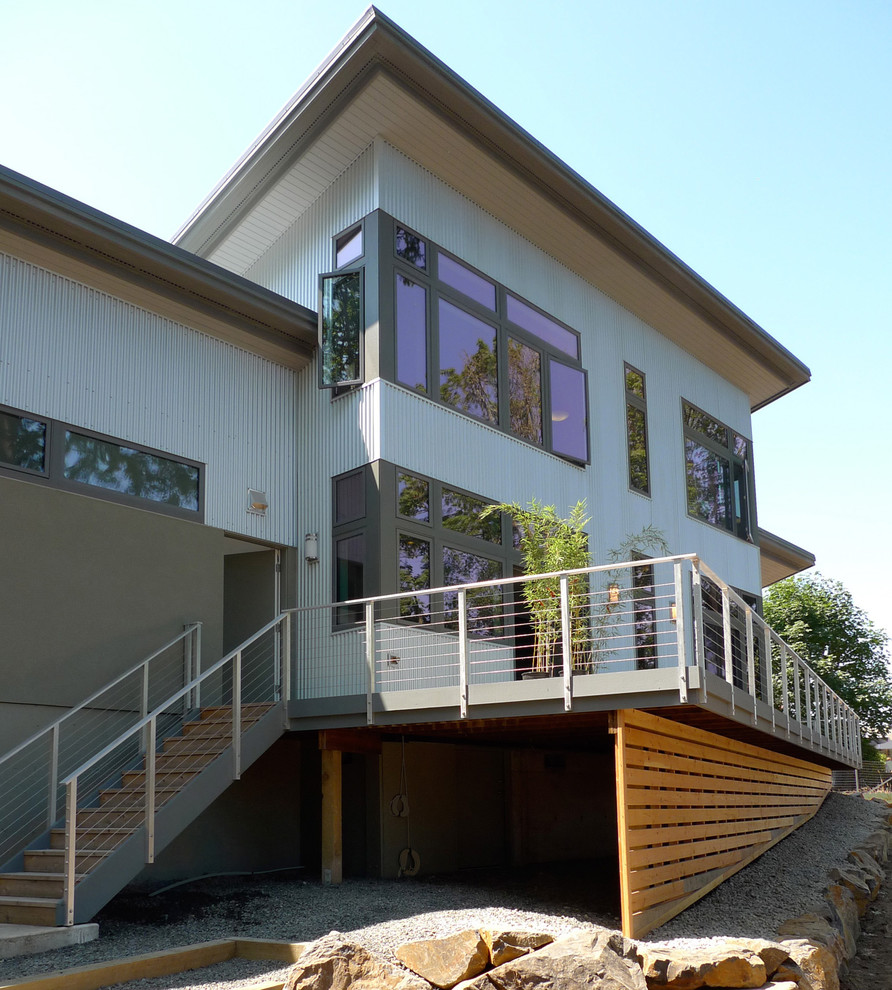 Photo of a large contemporary two-storey grey exterior in Portland with metal siding and a flat roof.
