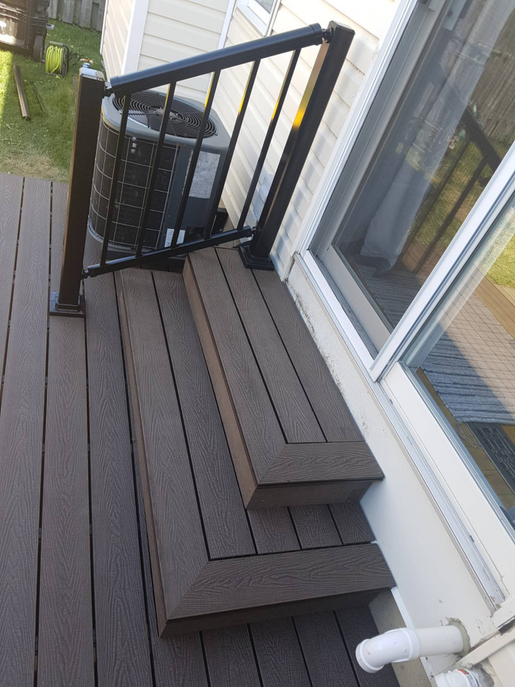 Example of a mid-sized transitional backyard metal railing deck design in Ottawa