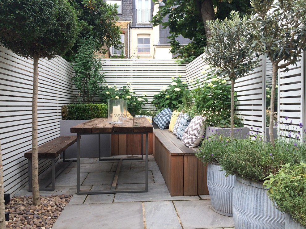 Ispirazione per un piccolo patio o portico minimalista dietro casa con un giardino in vaso e pavimentazioni in pietra naturale