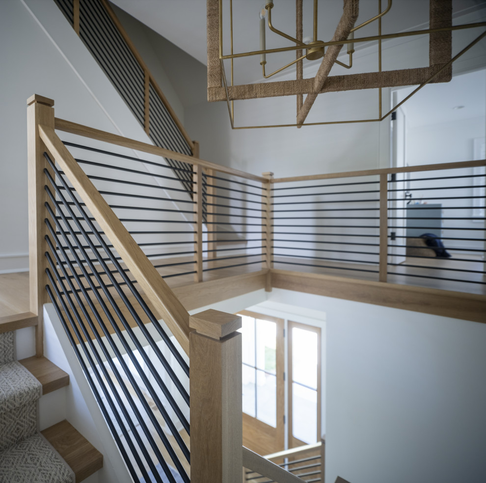 Imagen de escalera recta moderna extra grande con escalones de madera, contrahuellas de madera pintada y barandilla de madera