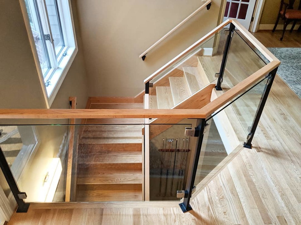 Photo of a modern wood l-shaped staircase in New York with wood risers and wood railing.